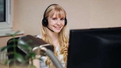 Gina Heise mit Kopfhörern am Arbeitsplatz - NMF OHG